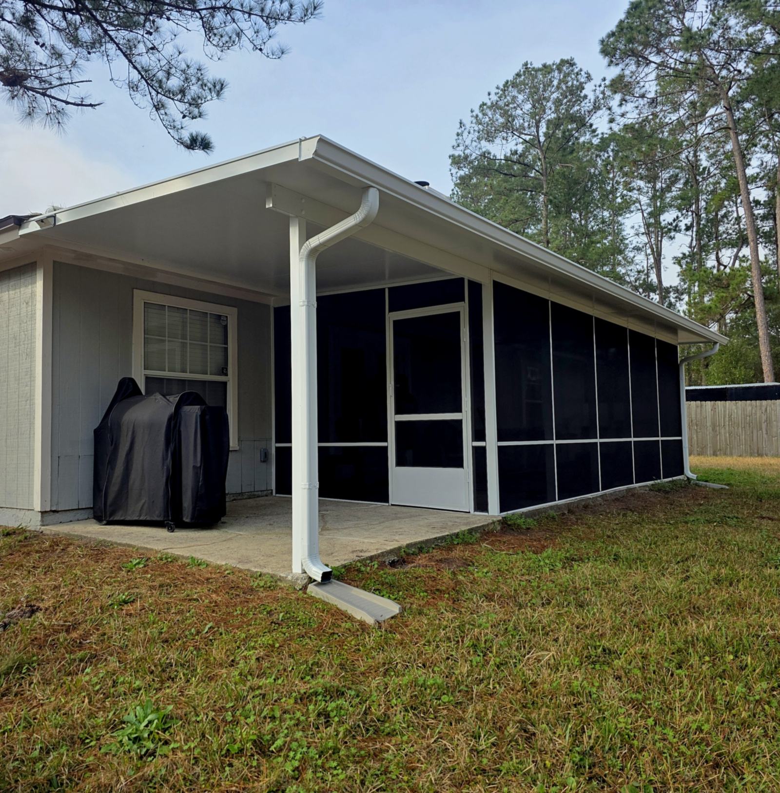Screen room with a patio cover extending over an open patio, built by Better Home Improvement in Jacksonville, FL